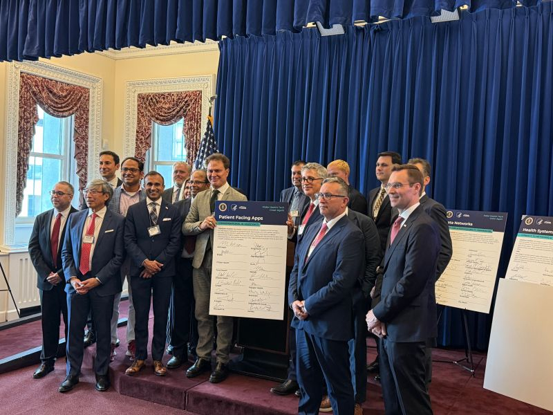 Dr. Omar Salah holding the signed pledge to launch NightingaleMD for CMS Members.